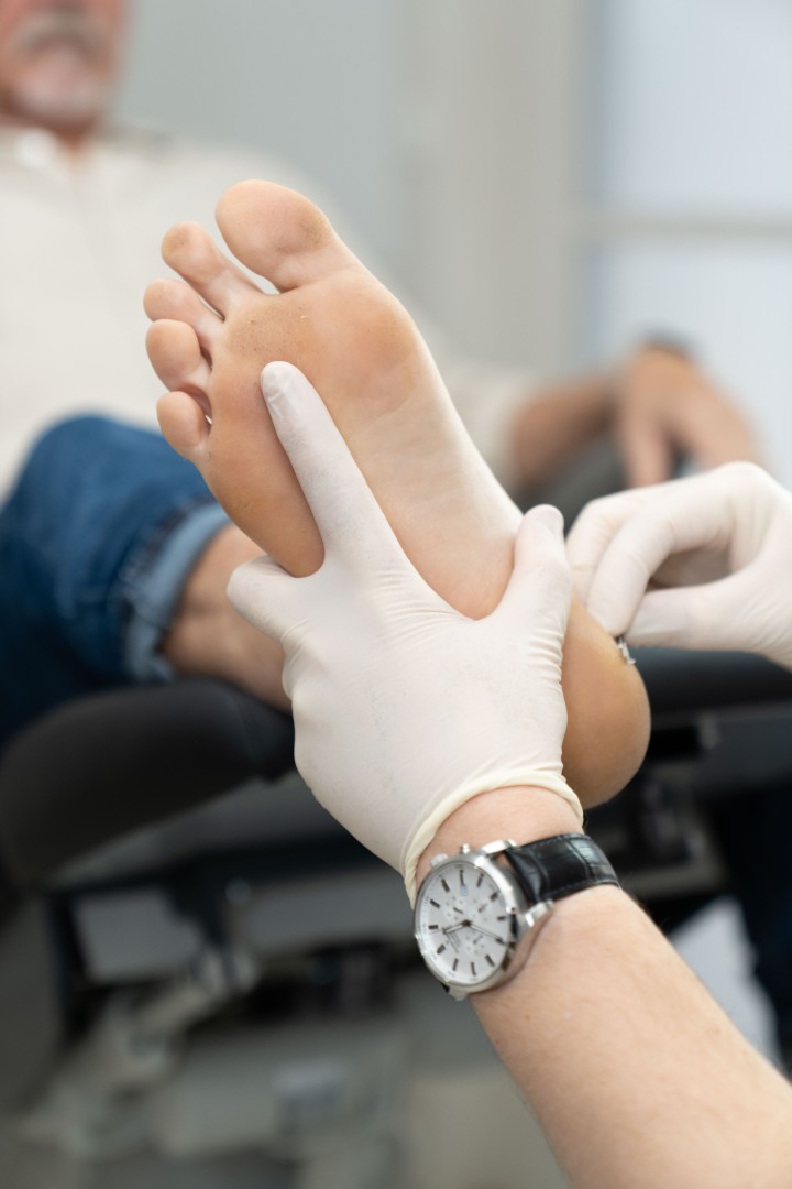 Podiatrist examining sole of patient’s foot