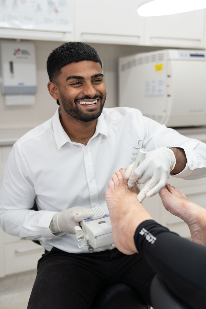 Podiatrist treating patient’s foot in clinic