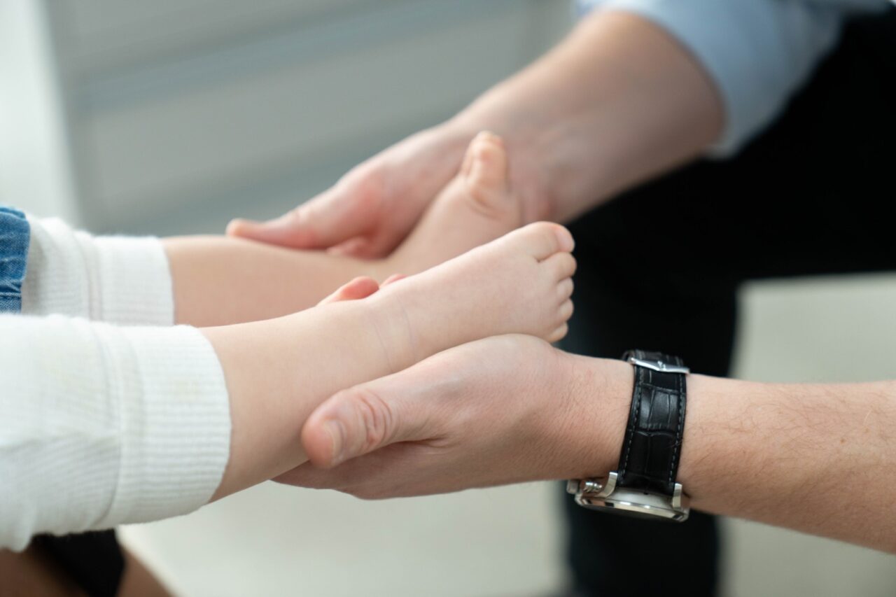 Adult hands gently holding baby's feet